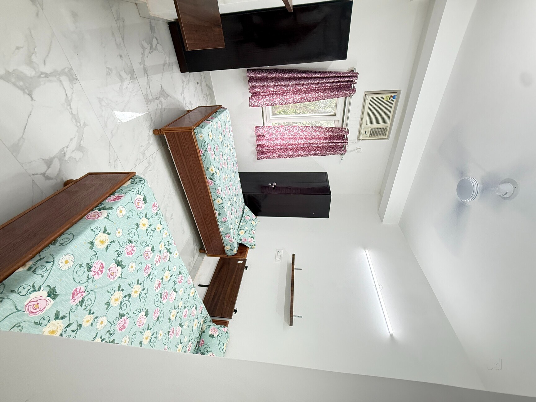 Bright bedroom with floral bedding and AC